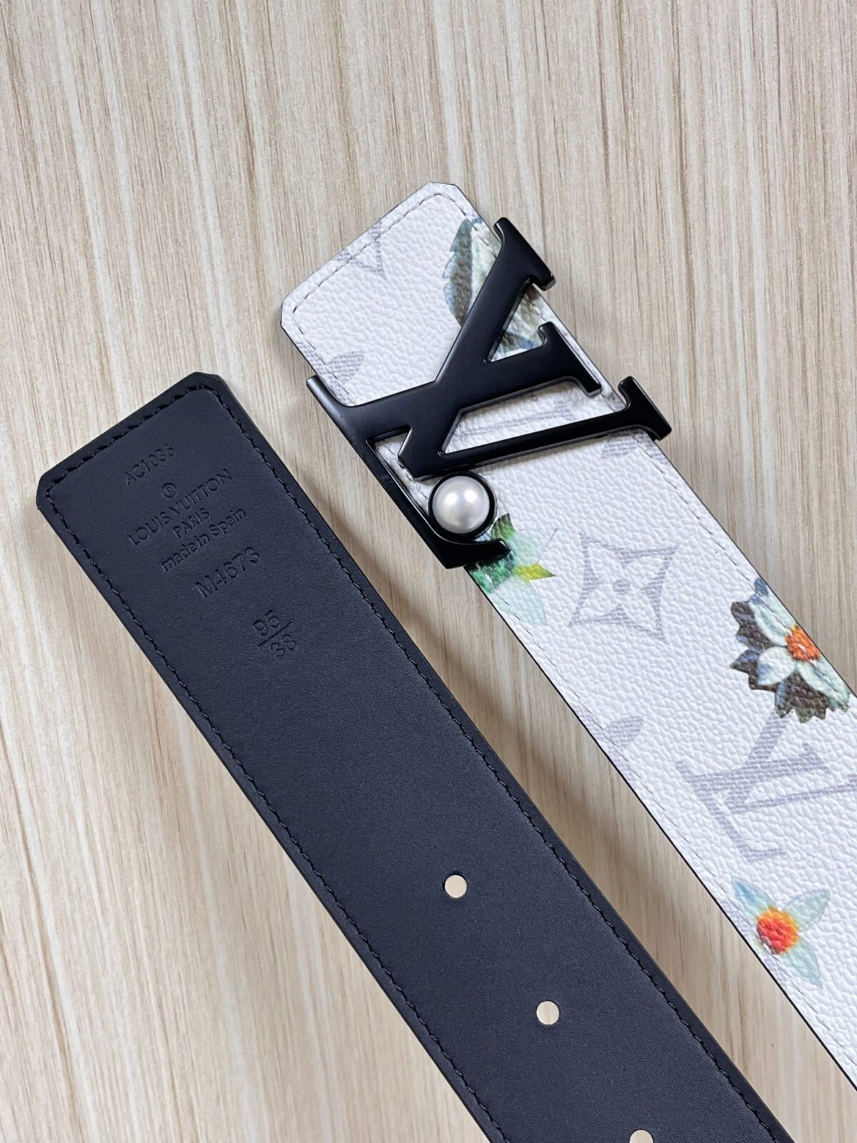 P150 当季新款，LV Initiales Monogram Flower系列40毫米可翻转腰带重新诠释了经典的LV标志，以唤起运动和情感的花纹。在画布一侧，Monogram通过添加白色和金色调的花朵，生动地描绘了每一片花瓣，赋予了它新的生命。白色的皮革背面同样优雅。 白花印百合花