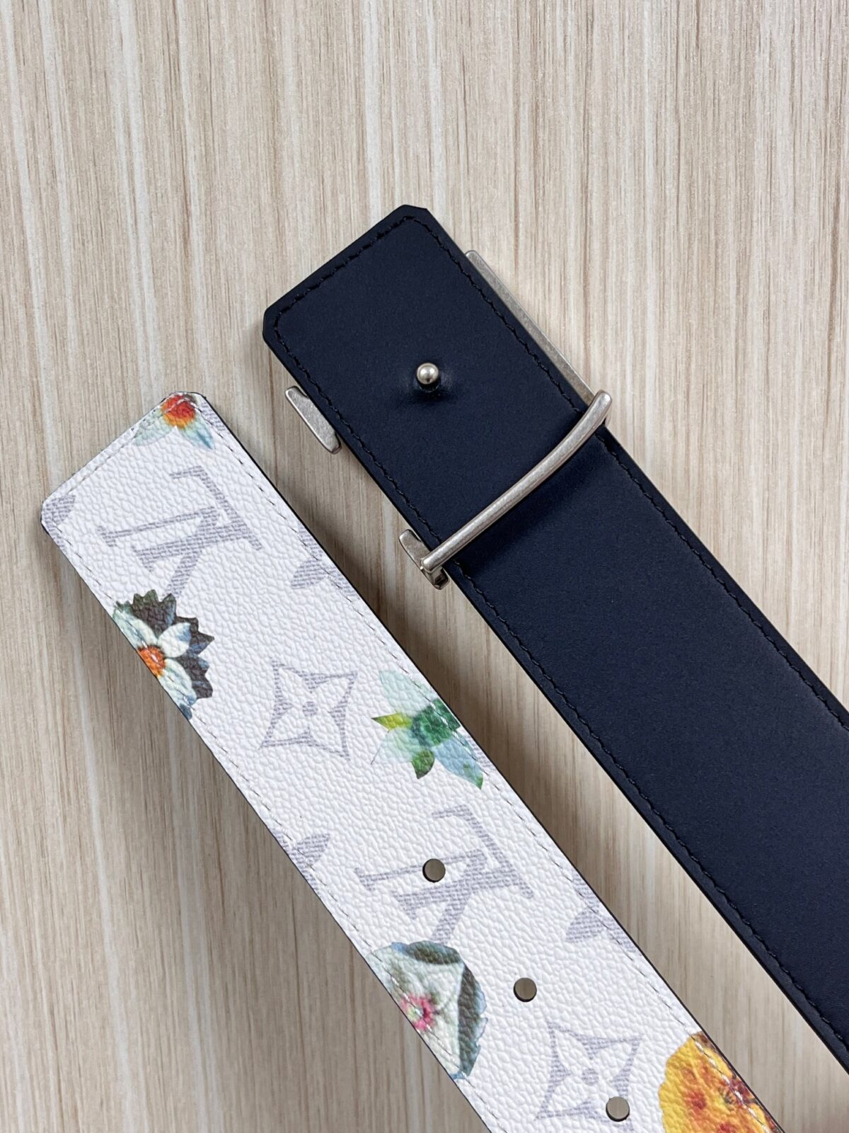 P150 当季新款，LV Initiales Monogram Flower系列40毫米可翻转腰带重新诠释了经典的LV标志，以唤起运动和情感的花纹。在画布一侧，Monogram通过添加白色和金色调的花朵，生动地描绘了每一片花瓣，赋予了它新的生命。白色的皮革背面同样优雅。 白花印百合花