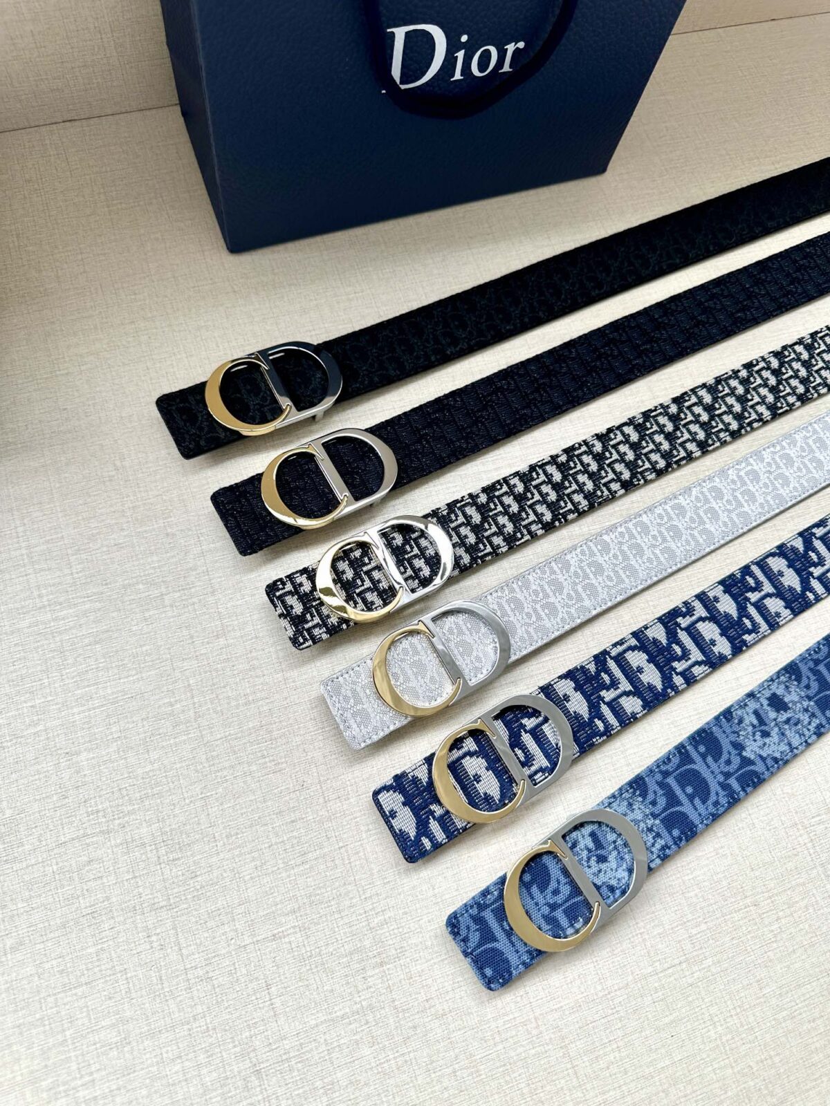 Dior 新款单品，延续经典设计，饰以 CD Icon 标志。光金和白色金属覆层形成鲜明的对比。可与各式 35 毫米腰带搭配，提升格调，打造优雅精致的造型。 /