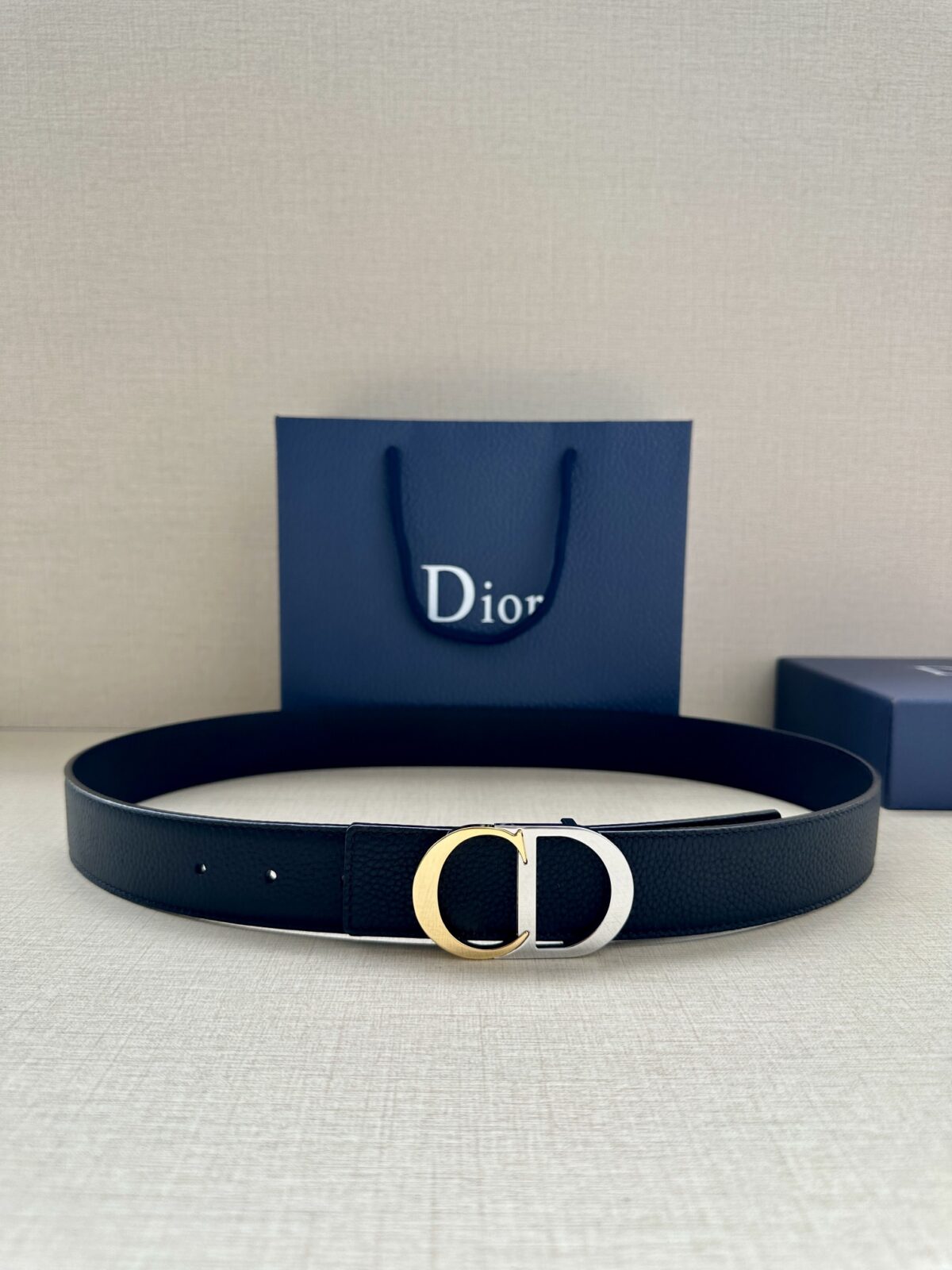 Dior 新款单品，延续经典设计，饰以 CD Icon 标志。光金和白色金属覆层形成鲜明的对比。可与各式 35 毫米腰带搭配，提升格调，打造优雅精致的造型。 /