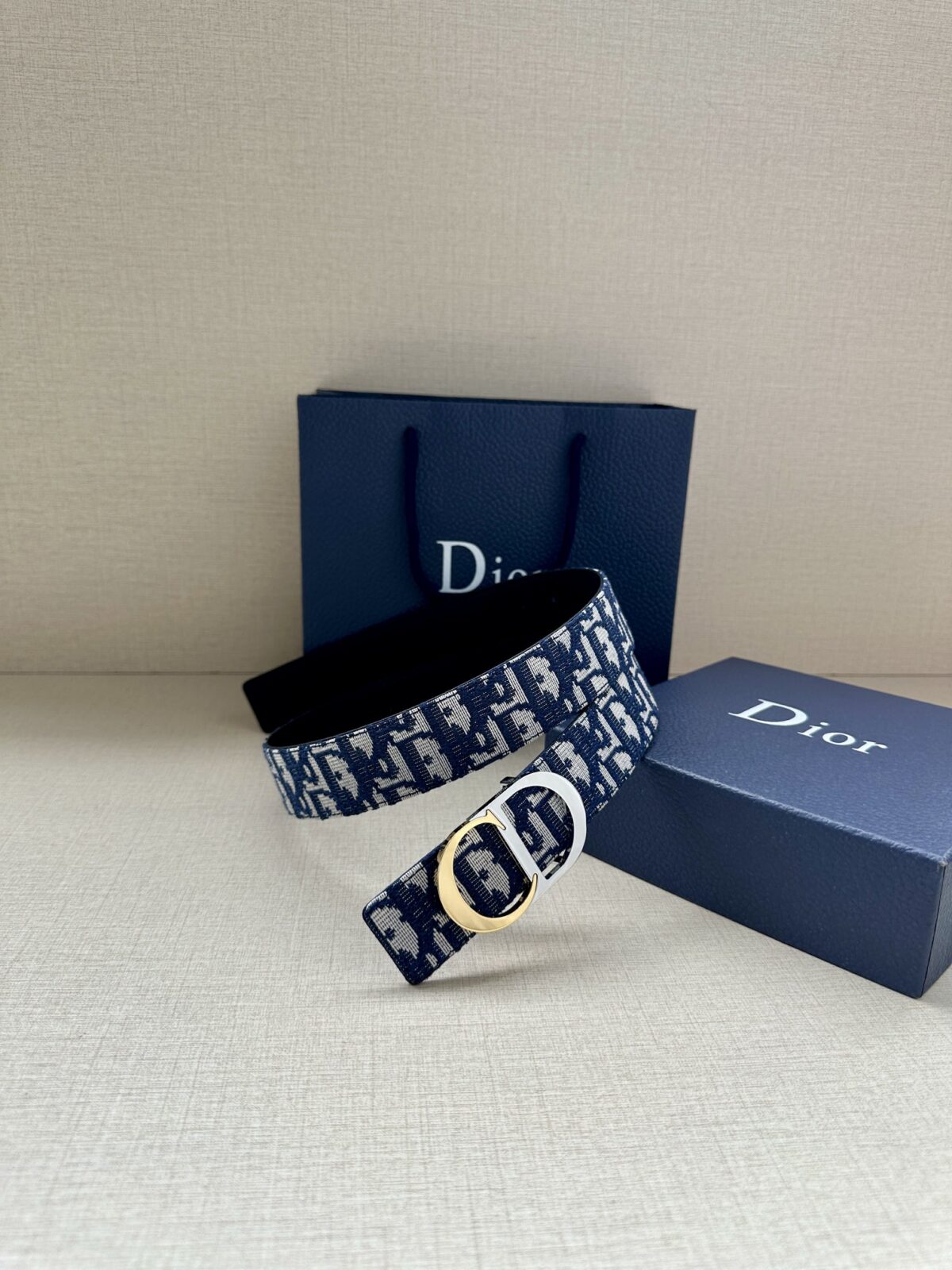 Dior 新款单品，延续经典设计，饰以 CD Icon 标志。光金和白色金属覆层形成鲜明的对比。可与各式 35 毫米腰带搭配，提升格调，打造优雅精致的造型。 /