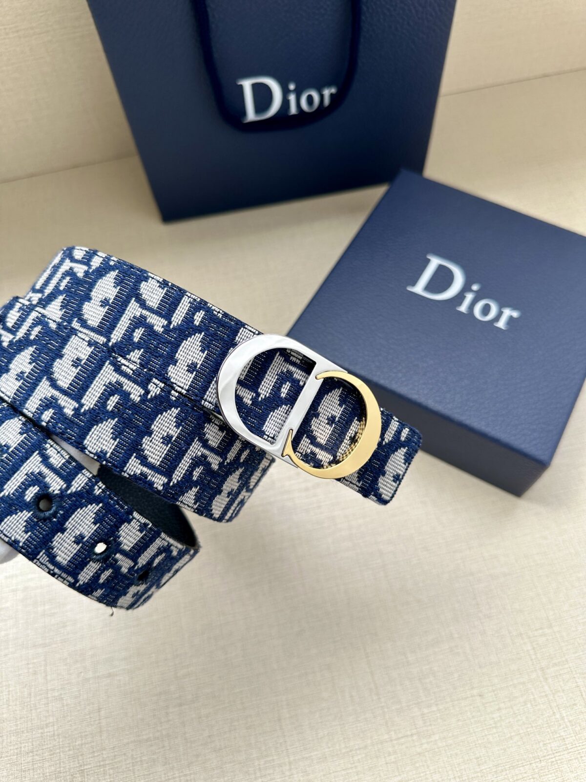 Dior 新款单品，延续经典设计，饰以 CD Icon 标志。光金和白色金属覆层形成鲜明的对比。可与各式 35 毫米腰带搭配，提升格调，打造优雅精致的造型。 /