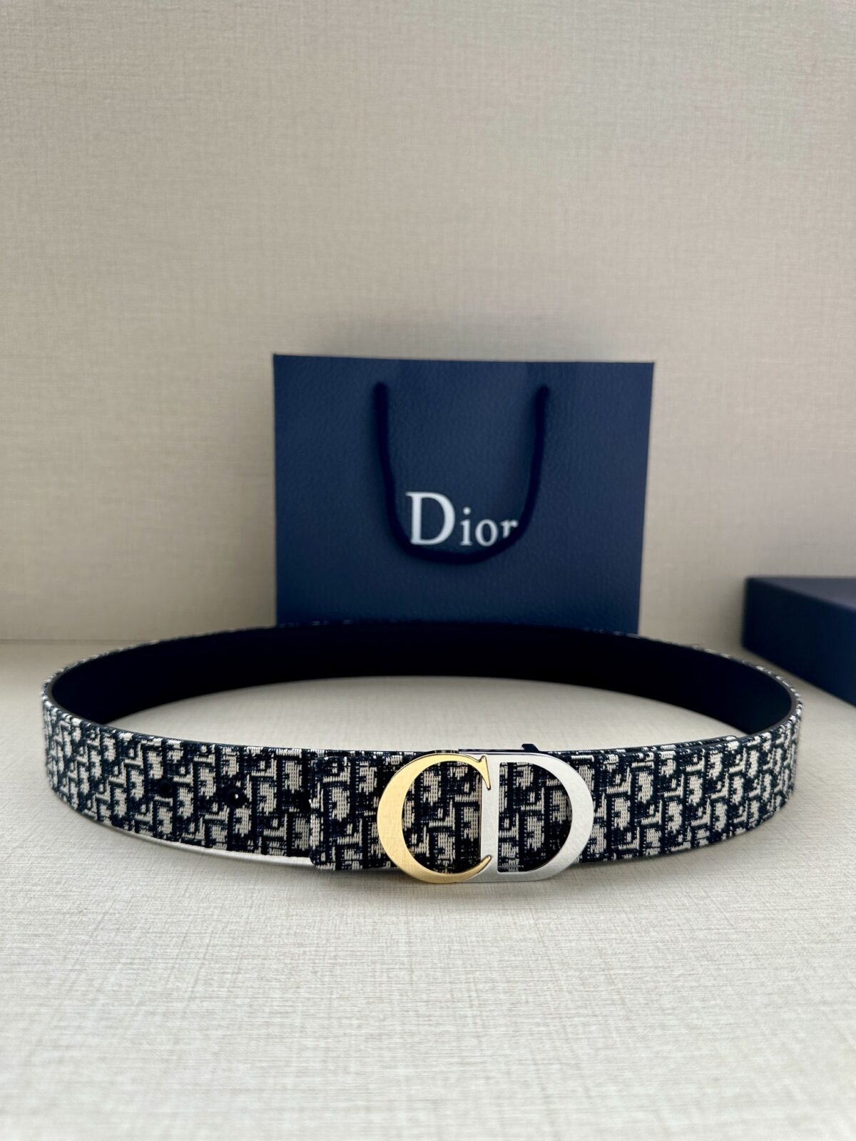 Dior 新款单品，延续经典设计，饰以 CD Icon 标志。光金和白色金属覆层形成鲜明的对比。可与各式 35 毫米腰带搭配，提升格调，打造优雅精致的造型。 /
