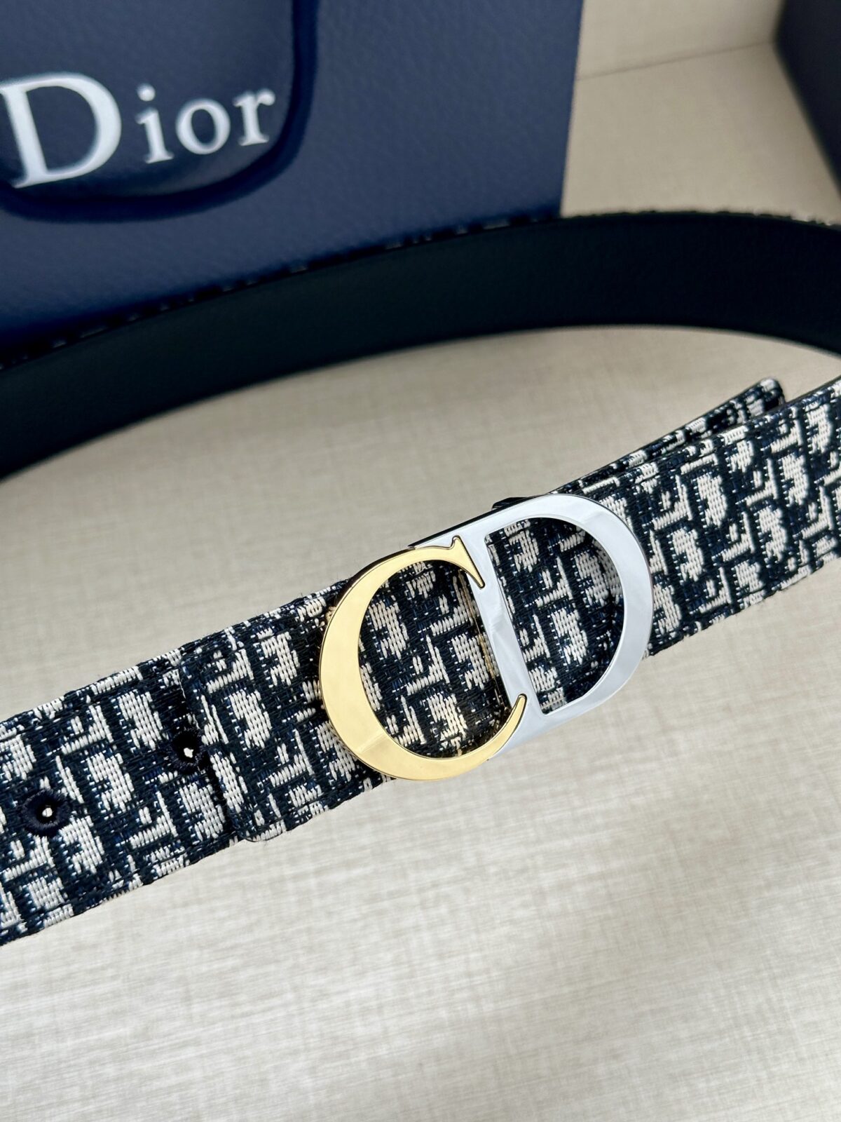 Dior 新款单品，延续经典设计，饰以 CD Icon 标志。光金和白色金属覆层形成鲜明的对比。可与各式 35 毫米腰带搭配，提升格调，打造优雅精致的造型。 /