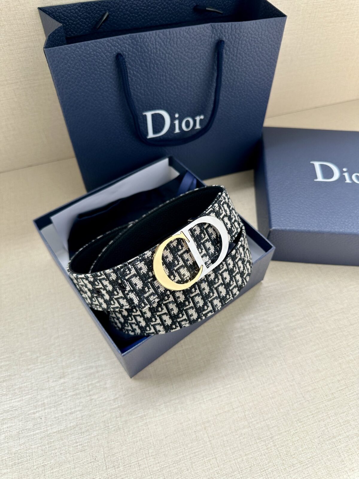 Dior 新款单品，延续经典设计，饰以 CD Icon 标志。光金和白色金属覆层形成鲜明的对比。可与各式 35 毫米腰带搭配，提升格调，打造优雅精致的造型。 /