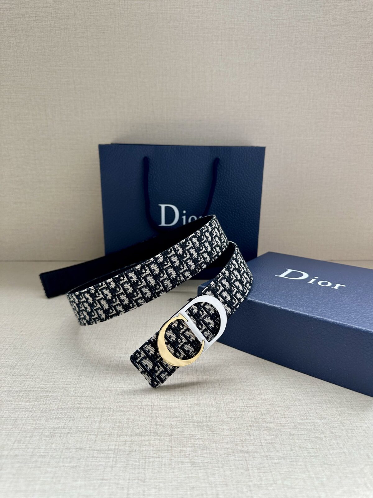 Dior 新款单品，延续经典设计，饰以 CD Icon 标志。光金和白色金属覆层形成鲜明的对比。可与各式 35 毫米腰带搭配，提升格调，打造优雅精致的造型。 /
