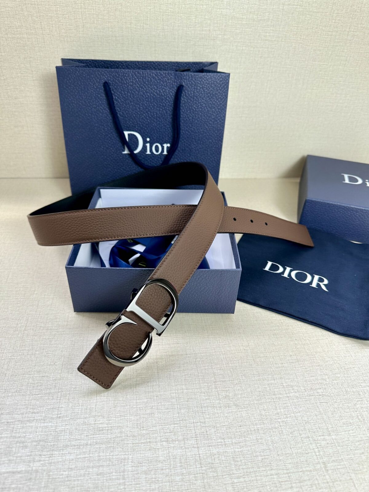 Dior 这款双面腰带结合典雅气质与摩登风范。双面均采用粒面牛皮革精心制作，一面为黑色，另一面为橄榄绿色、可搭配各式 35 毫米腰带扣，更添精致，打造富有个性特色的配饰，时尚百搭。 /