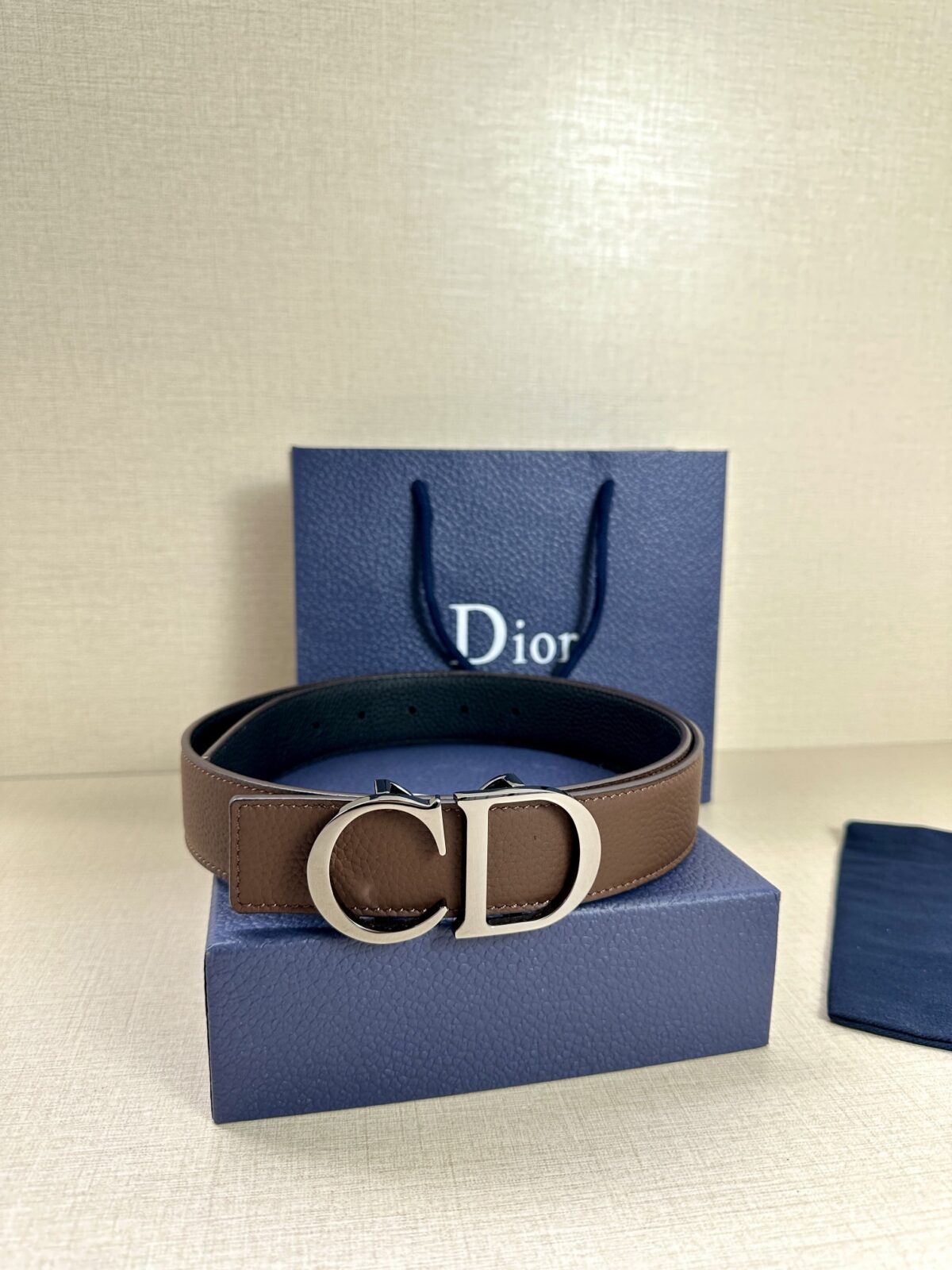 Dior 这款双面腰带结合典雅气质与摩登风范。双面均采用粒面牛皮革精心制作，一面为黑色，另一面为橄榄绿色、可搭配各式 35 毫米腰带扣，更添精致，打造富有个性特色的配饰，时尚百搭。 /