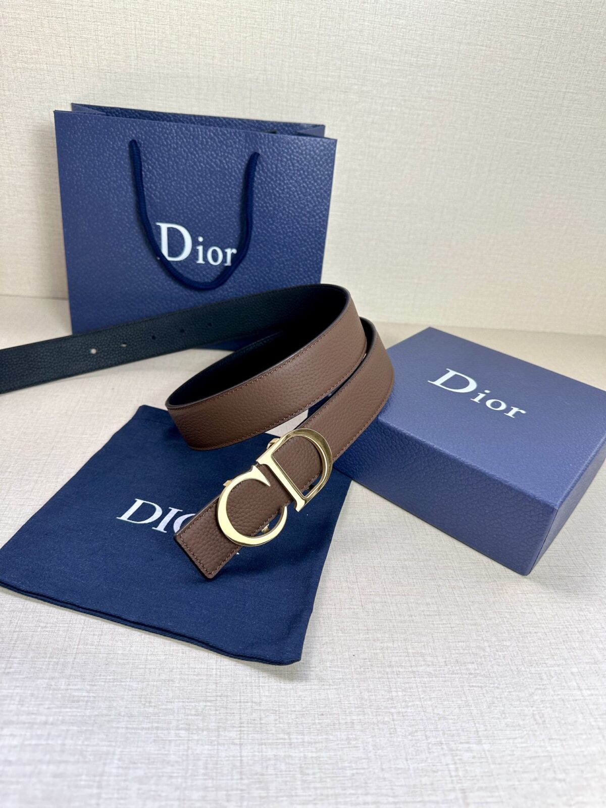 Dior 这款双面腰带结合典雅气质与摩登风范。双面均采用粒面牛皮革精心制作，一面为黑色，另一面为橄榄绿色、可搭配各式 35 毫米腰带扣，更添精致，打造富有个性特色的配饰，时尚百搭。 /