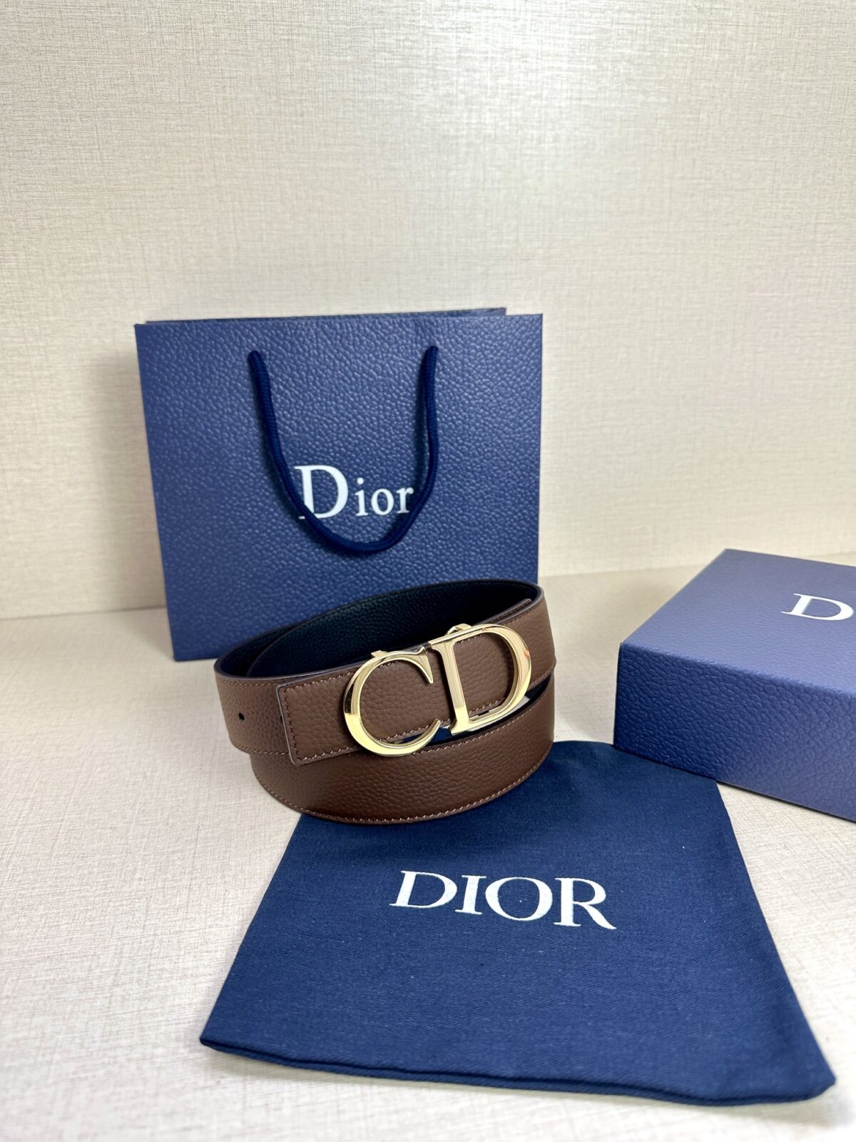 Dior 这款双面腰带结合典雅气质与摩登风范。双面均采用粒面牛皮革精心制作，一面为黑色，另一面为橄榄绿色、可搭配各式 35 毫米腰带扣，更添精致，打造富有个性特色的配饰，时尚百搭。 /