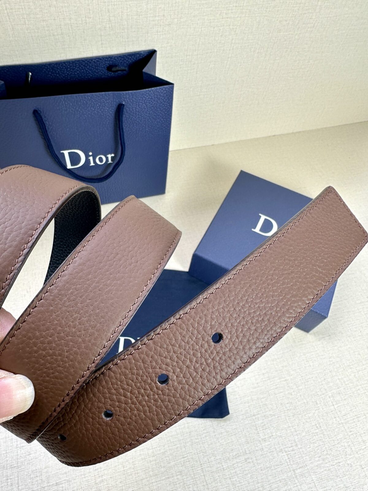 Dior 这款双面腰带结合典雅气质与摩登风范。双面均采用粒面牛皮革精心制作，一面为黑色，另一面为橄榄绿色、可搭配各式 35 毫米腰带扣，更添精致，打造富有个性特色的配饰，时尚百搭。 /