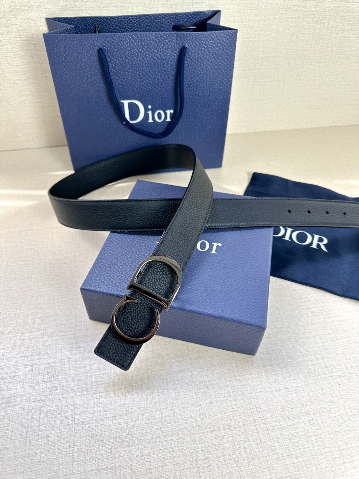 Dior 这款双面腰带结合典雅气质与摩登风范。双面均采用粒面牛皮革精心制作，一面为黑色，另一面为天蓝色、可搭配各式 35 毫米腰带扣，更添精致，打造富有个性特色的配饰，时尚百搭。 /