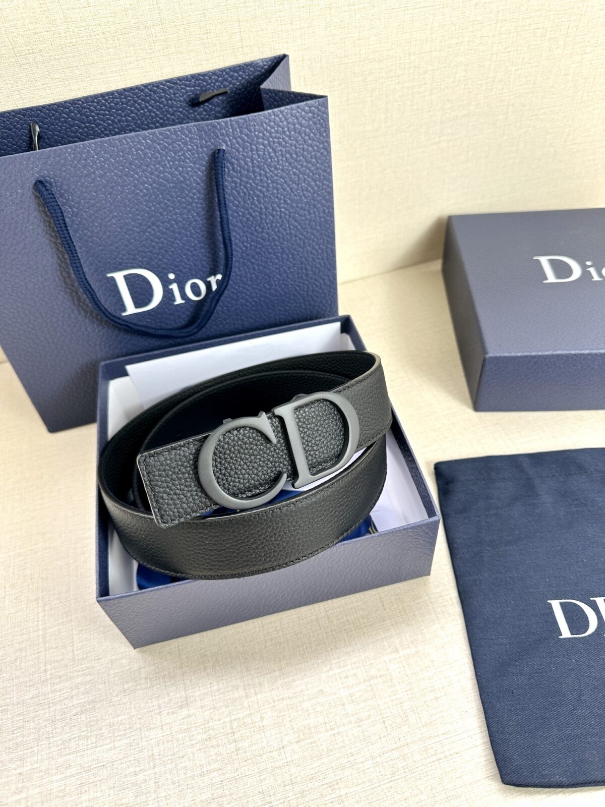 Dior 这款双面腰带结合典雅气质与摩登风范。双面均采用粒面牛皮革精心制作，一面为黑色，另一面为中国红、可搭配各式 35 毫米腰带扣，更添精致，打造富有个性特色的配饰，时尚百搭。 /