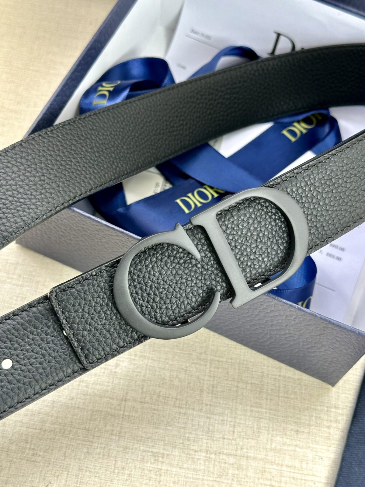 Dior 这款双面腰带结合典雅气质与摩登风范。双面均采用粒面牛皮革精心制作，一面为黑色，另一面为中国红、可搭配各式 35 毫米腰带扣，更添精致，打造富有个性特色的配饰，时尚百搭。 /