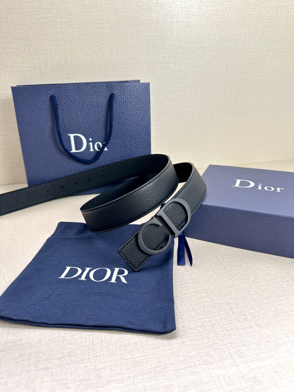 Dior 这款双面腰带结合典雅气质与摩登风范。双面均采用粒面牛皮革精心制作，一面为黑色，另一面为中国红、可搭配各式 35 毫米腰带扣，更添精致，打造富有个性特色的配饰，时尚百搭。 /